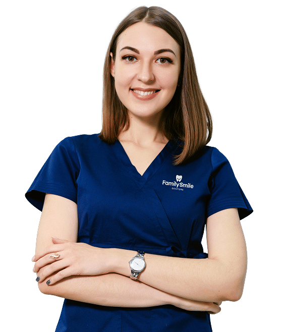 Smiling dental professional in navy scrubs with folded arms, wearing a "Family Smile Center" uniform.