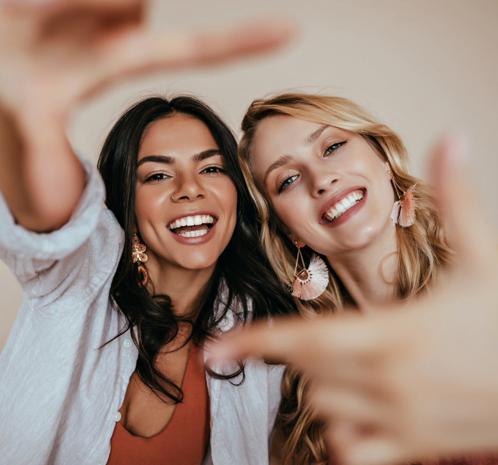 Two young women posing with smiles for the camera.